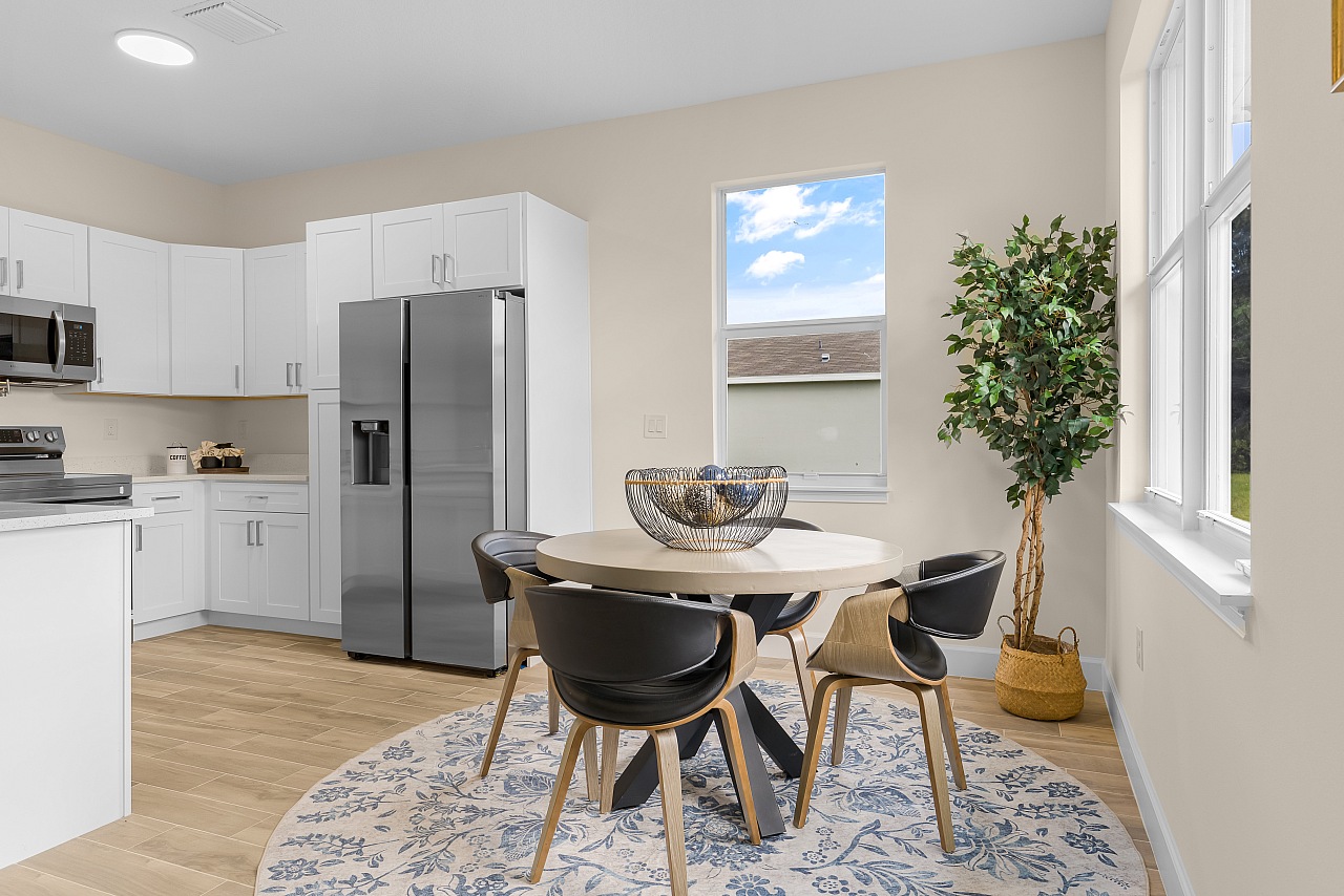 Dining area beside a modern kitchen in an Osuna Homes model